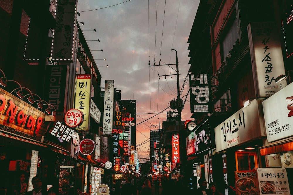 Seoul neighborhood streets with illuminated signs at dusk